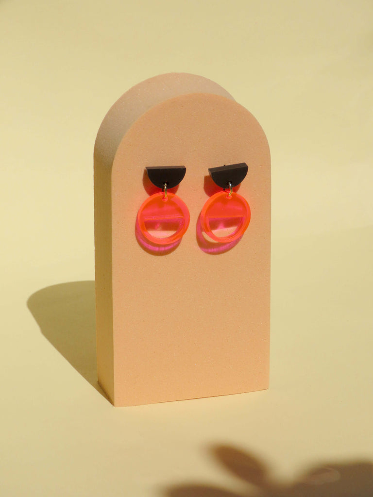 Leichte Acryl Ohrstecker mit schwarzem Halbkreis und leuchtendem Neon-Orange Kreis, hautfreundlicher Edelstahlverschluss
