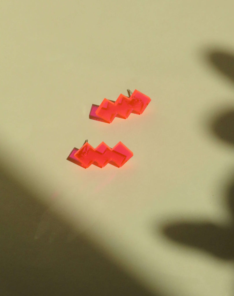 Neon-pinke Ohrstecker aus Acryl mit auffälligem, geometrischem Muster