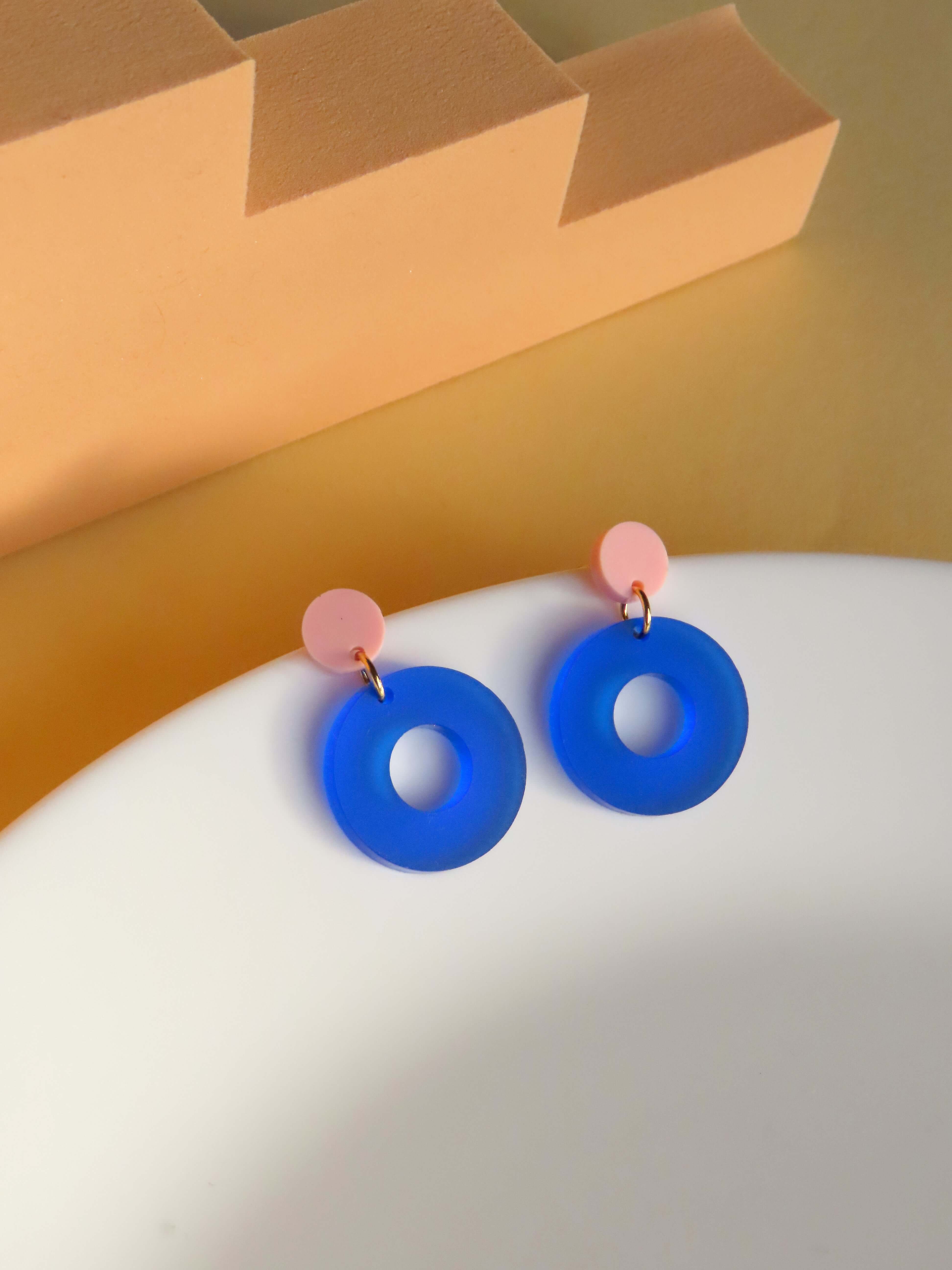Runde Ohrstecker aus glänzendem Acryl in Rosa und Tintenblau mit Edelstahlsteckern