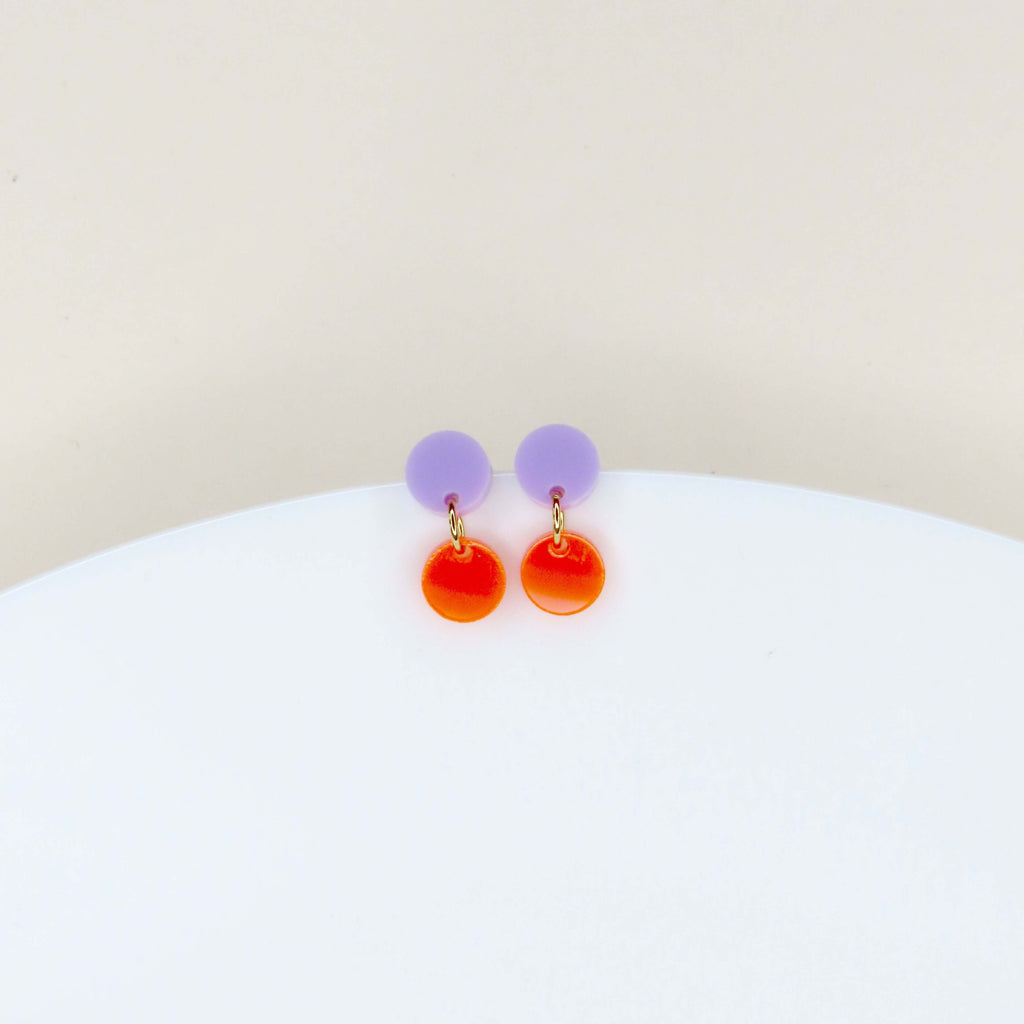 Ohrstecker aus mattem Acryl in Flieder mit glänzendem neonorangem Anhänger in Kreisform