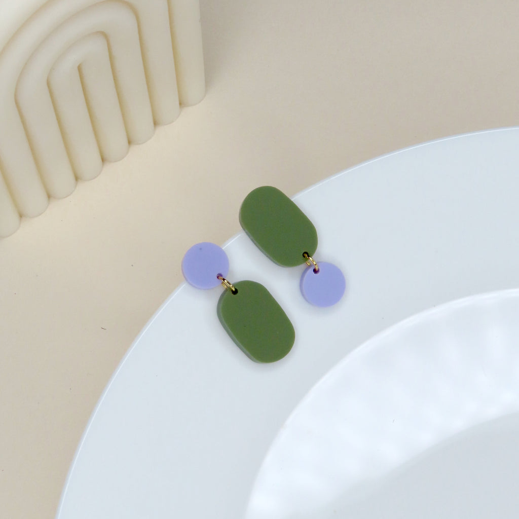 Asymmetrische Ohrstecker aus Acryl in Olivgrün und Flieder mit ovalem und rundem Element