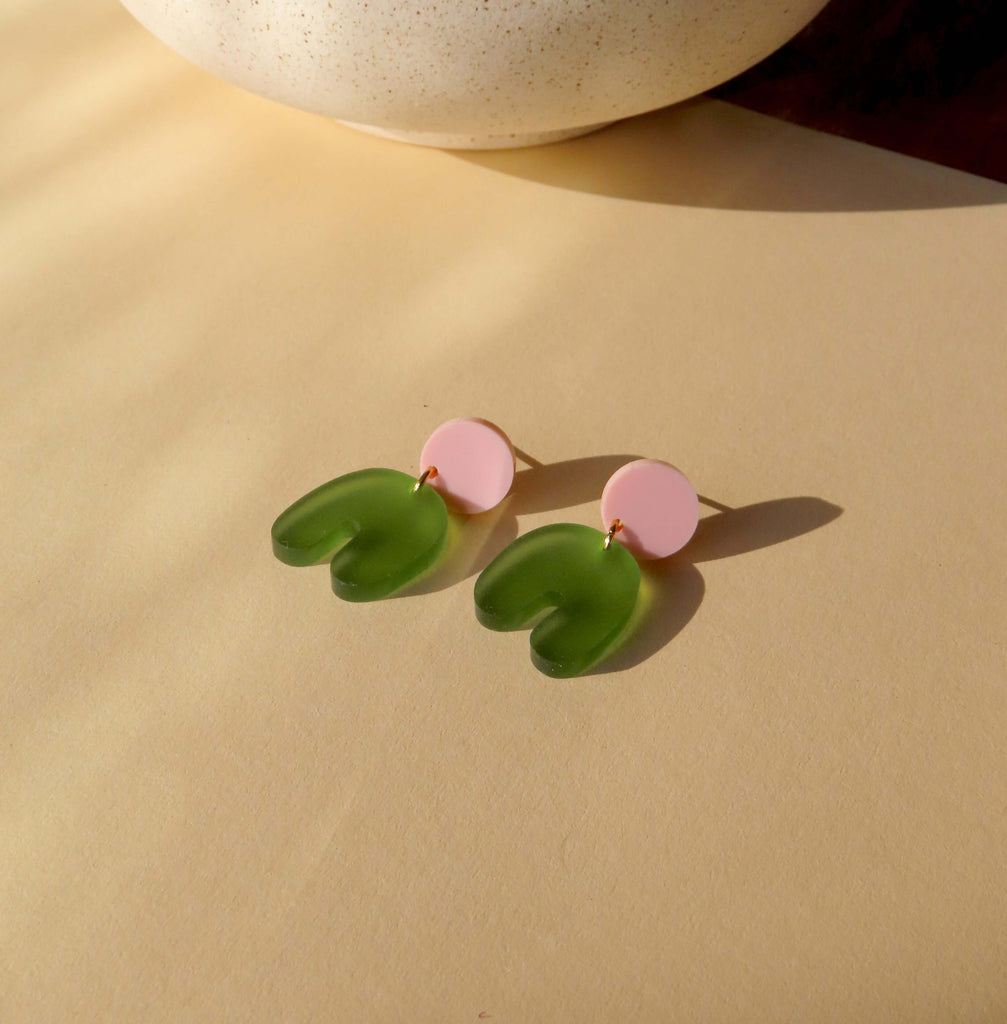 Verspielte Ohrringe aus Acryl in Rosa und transparentem Olivgrün mit U-förmigem Anhänger