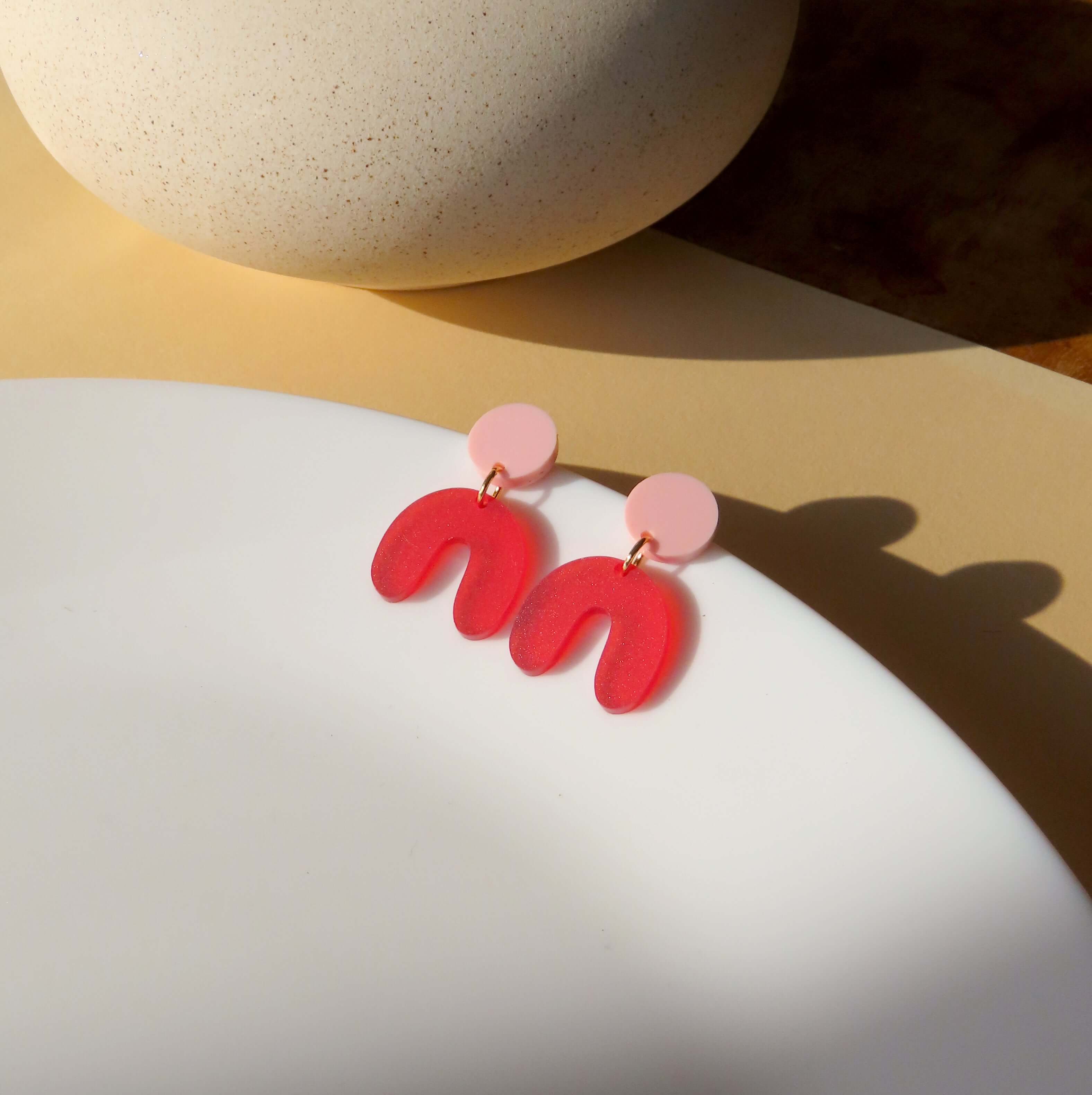 Ohrringe mit organischer U‑Form aus pastellrosa und signalrot, Acryl mit Edelstahlstecker