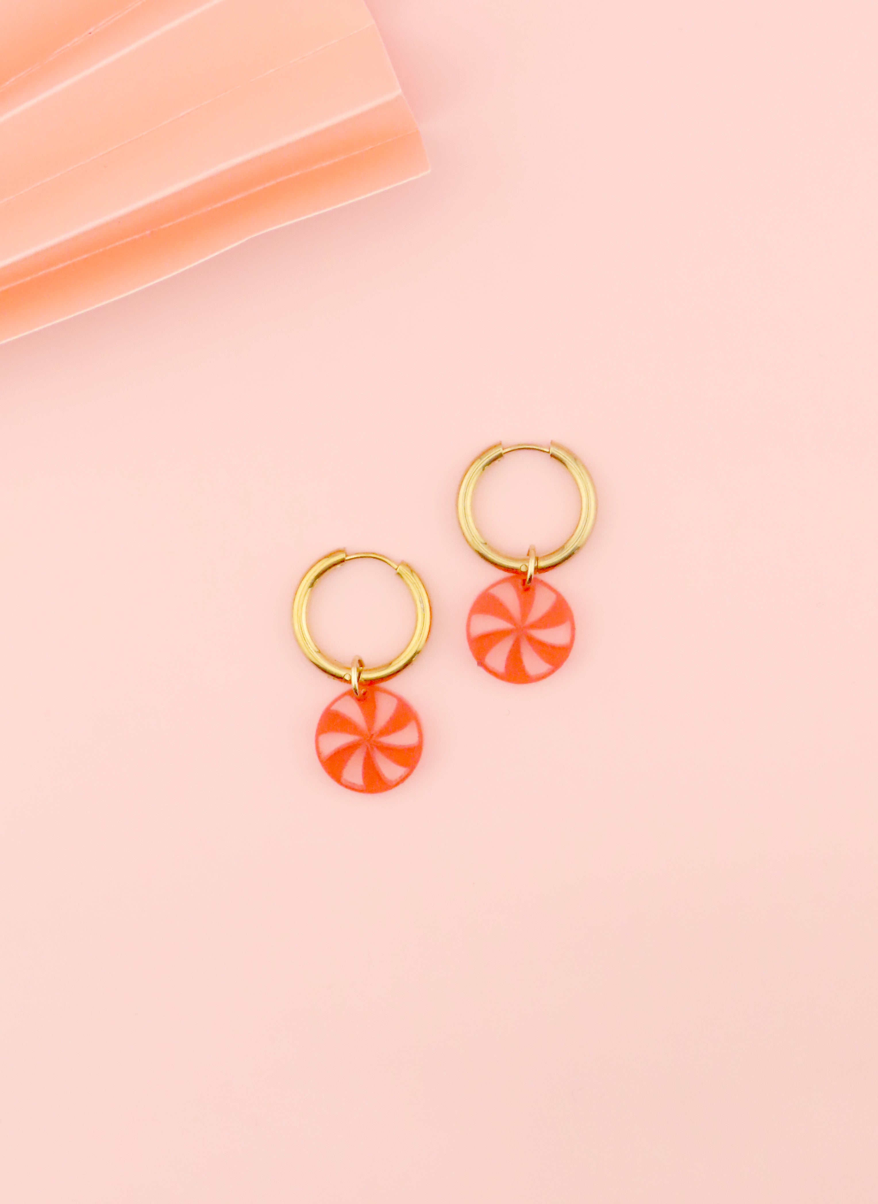 goldene edelstahl creolen mit rundem transparent rotem acryl anhaenger im candy design