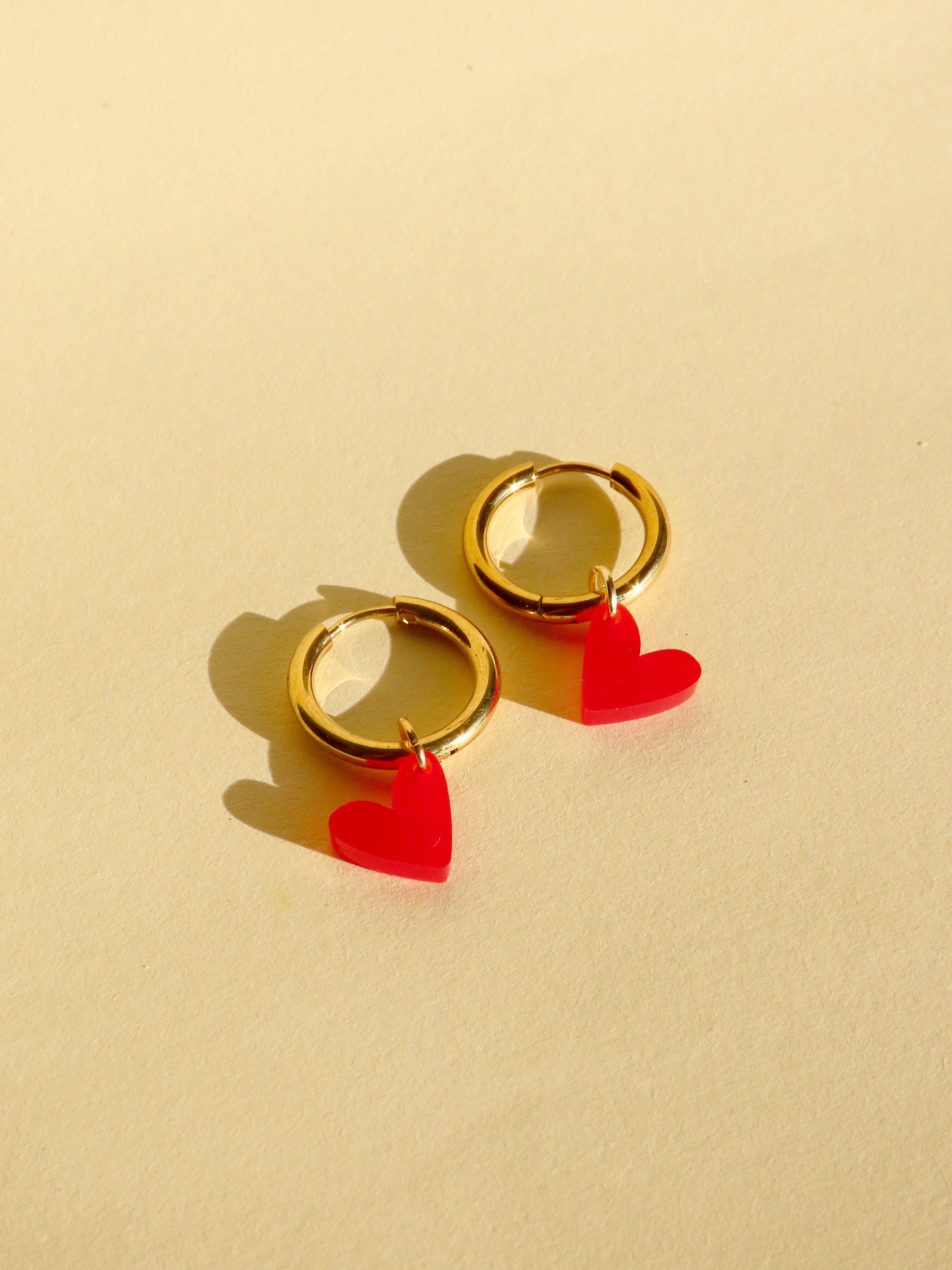 Kleine Creolen aus vergoldetem Edelstahl mit leuchtend rotem Herz aus Acryl