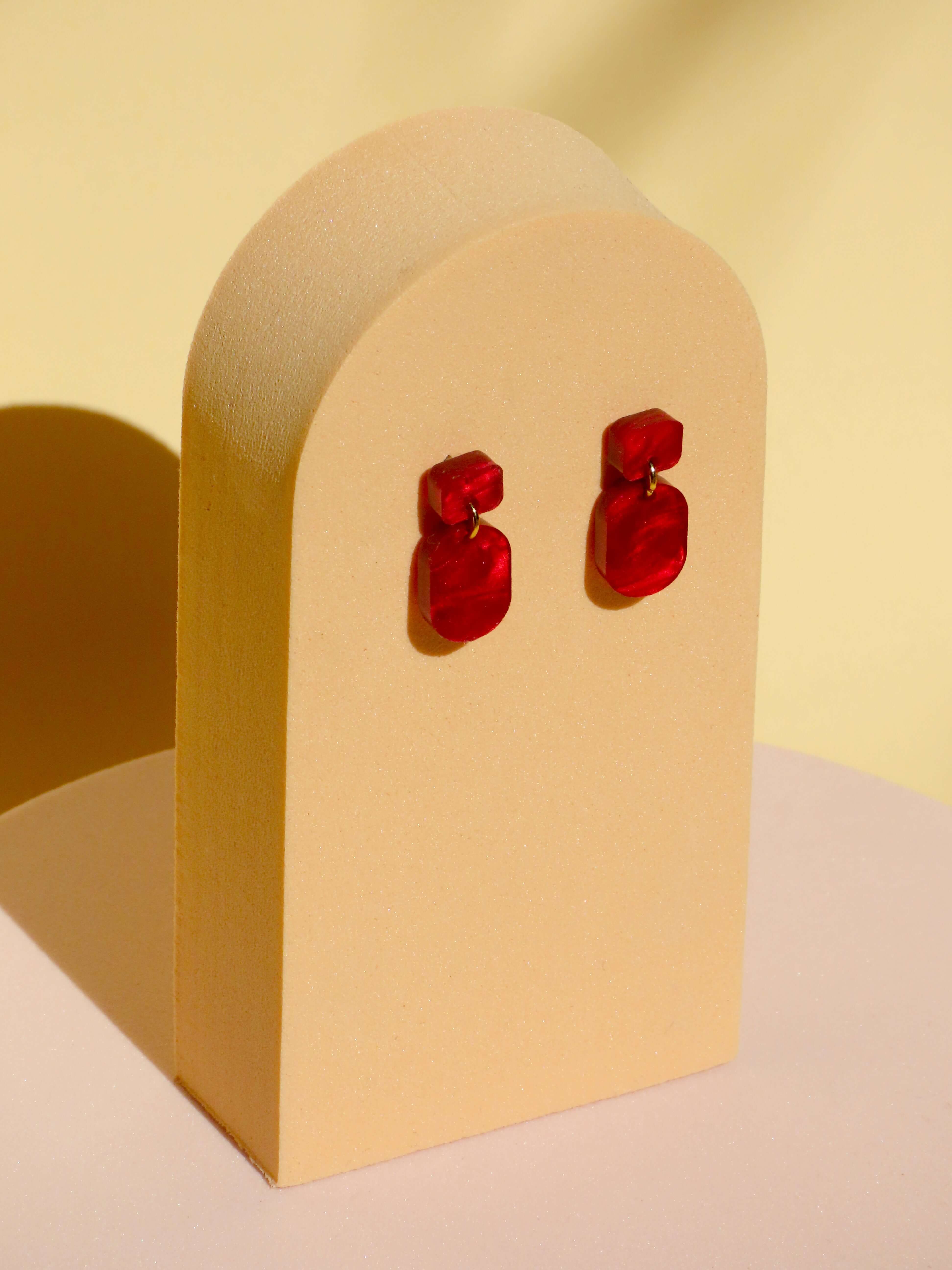 Rote Mini Ohrhänger mit eckigem Stecker und ovalem Anhänger aus Acryl in fließender Marmorierung