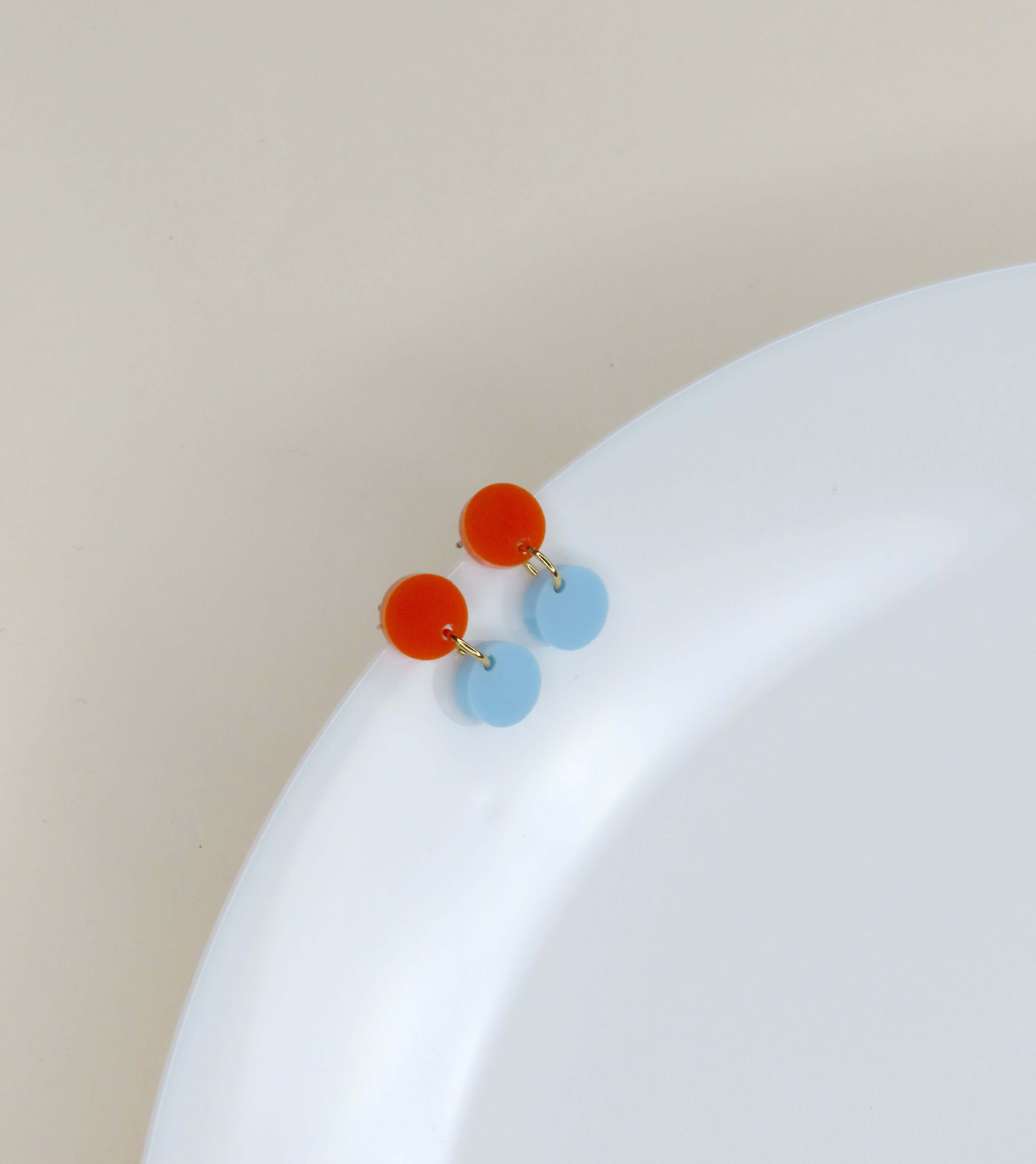 Minimalistische Acryl Ohrringe in runder Form, orangefarbener Stecker und blauer Anhänger