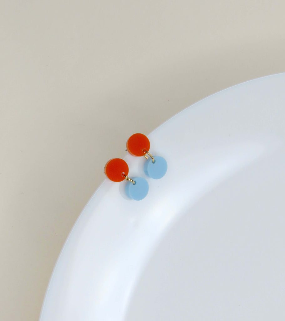 Minimalistische Acryl Ohrringe in runder Form, orangefarbener Stecker und blauer Anhänger