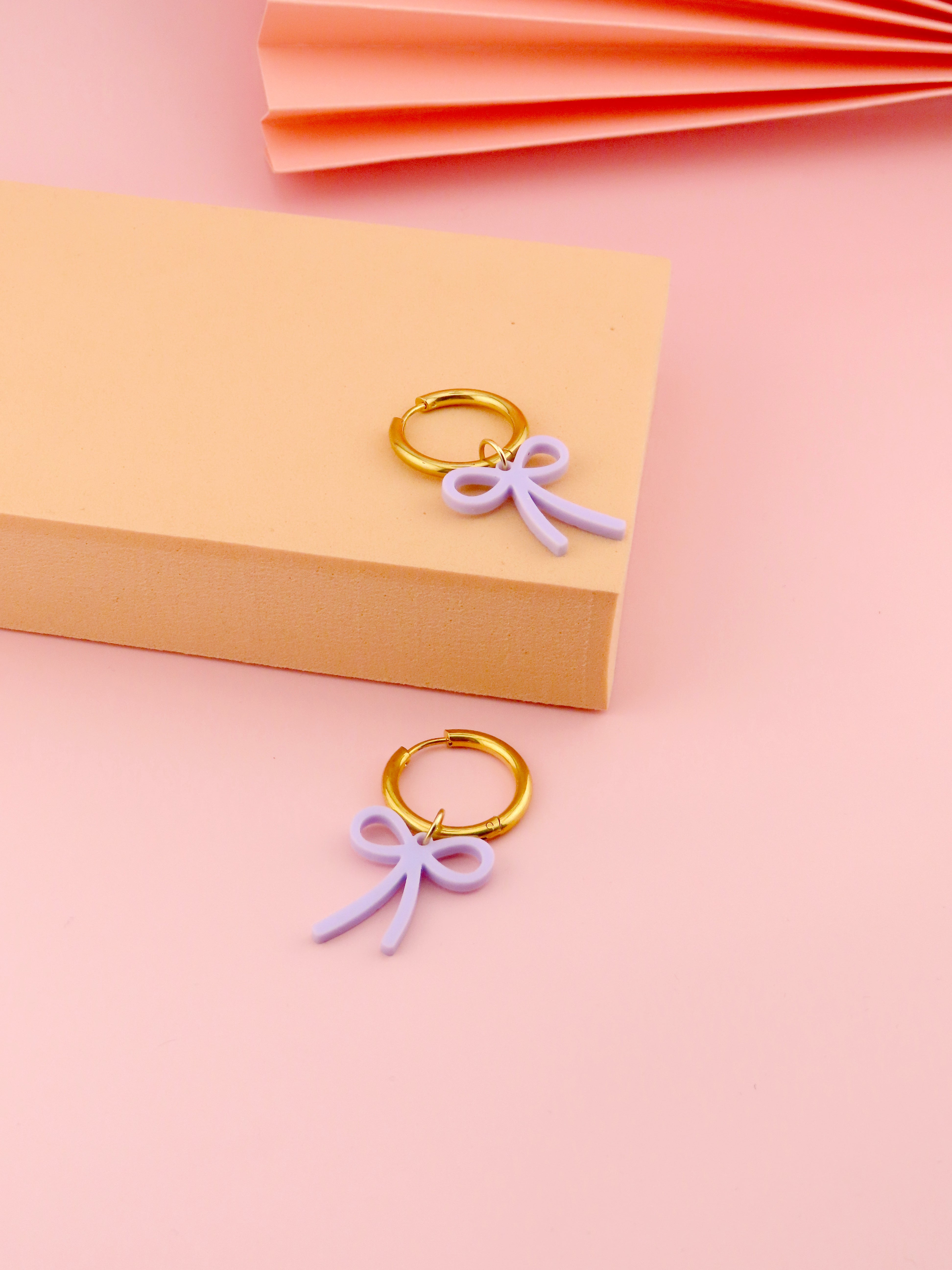 Fliederfarbene Schleifen Creolen aus Acryl mit vergoldetem Edelstahlring und feiner Schleifenform