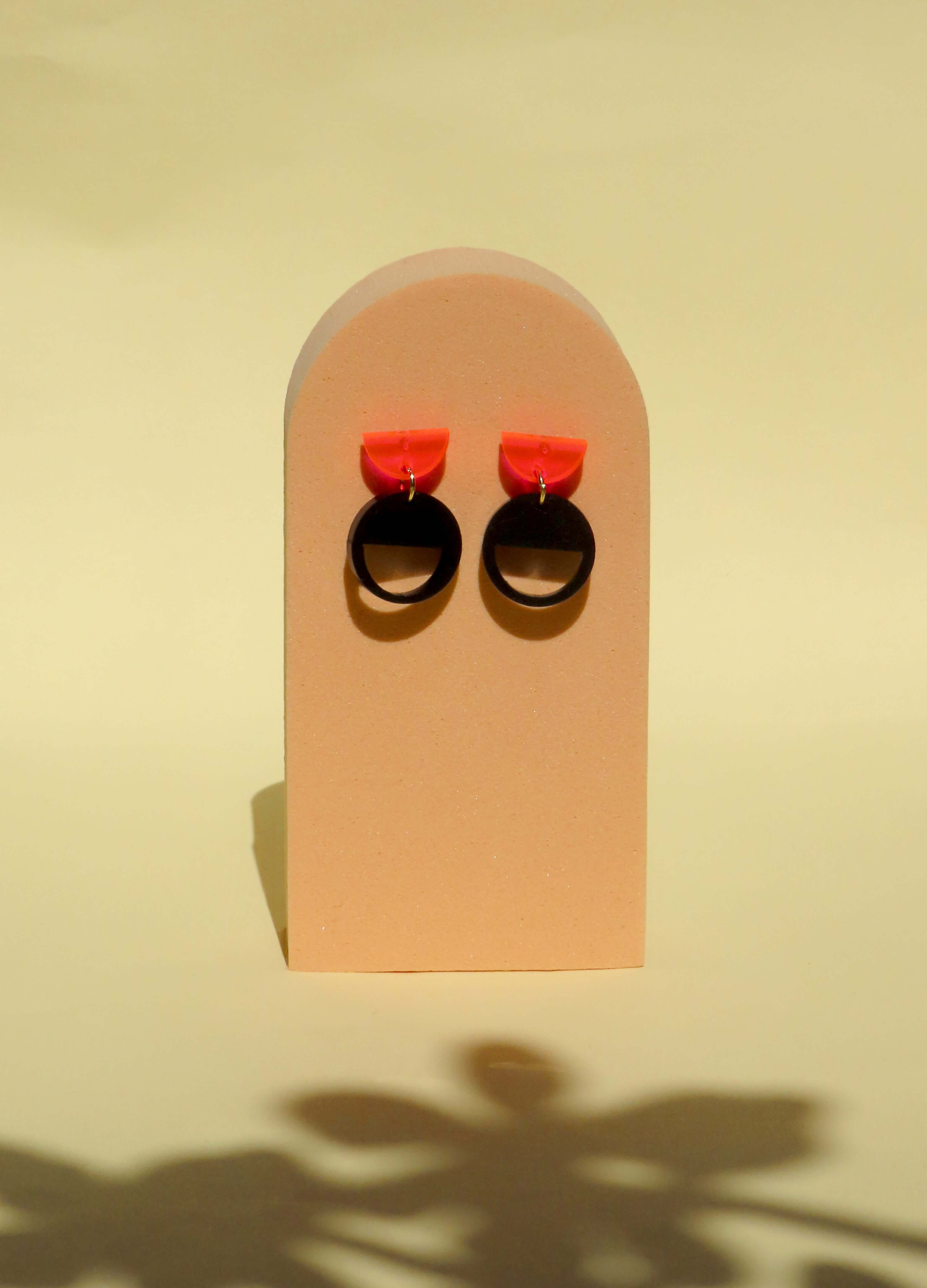 Ohrstecker aus Acryl mit neonpinkem Halbkreis und schwarzem Kreisanhänger