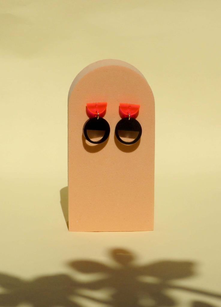 Ohrstecker aus Acryl mit neonpinkem Halbkreis und schwarzem Kreisanhänger