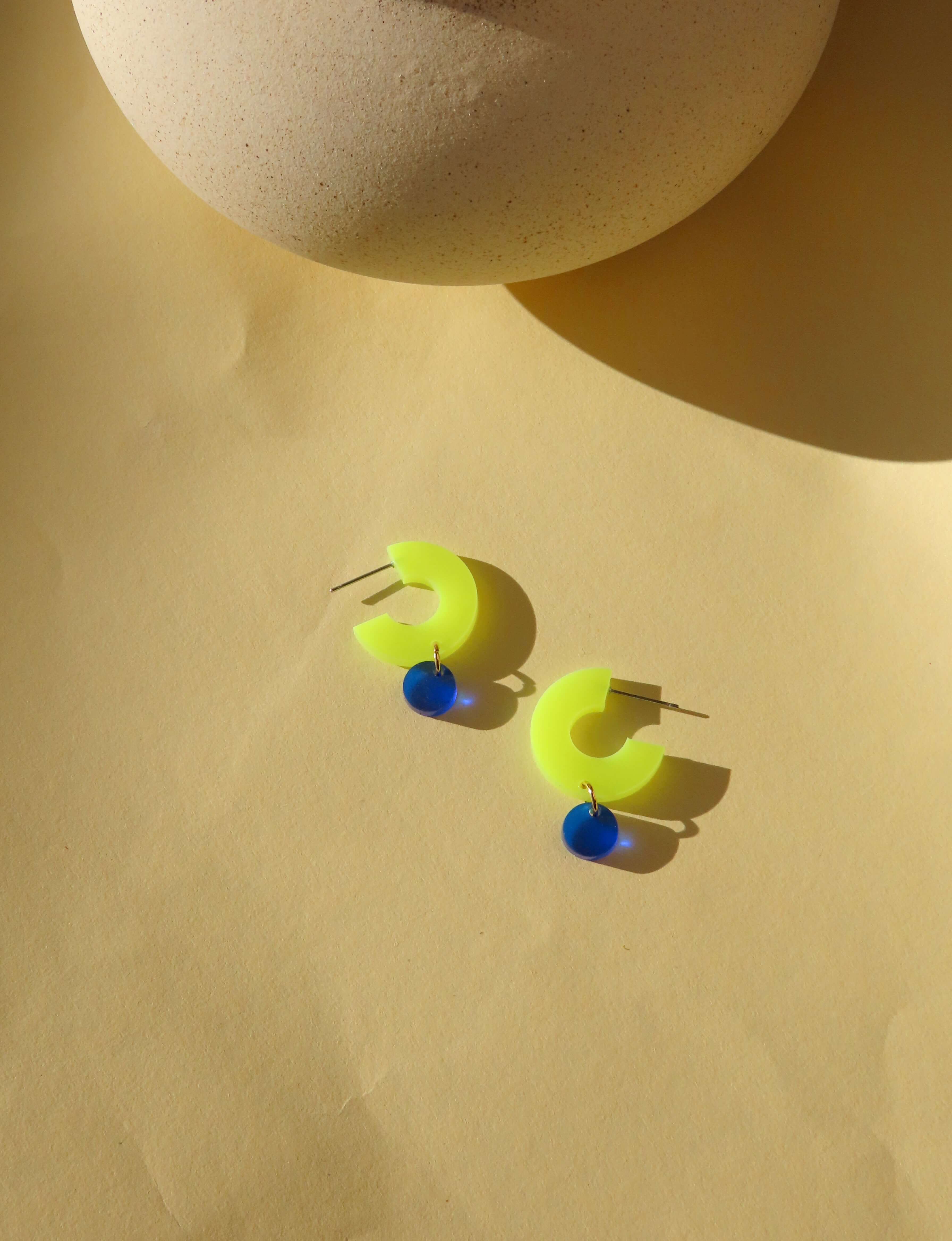 Silva Creolen aus Acryl in Neon-Gelb mit rundem Anhänger in Tiefblau und Edelstahlstecker
