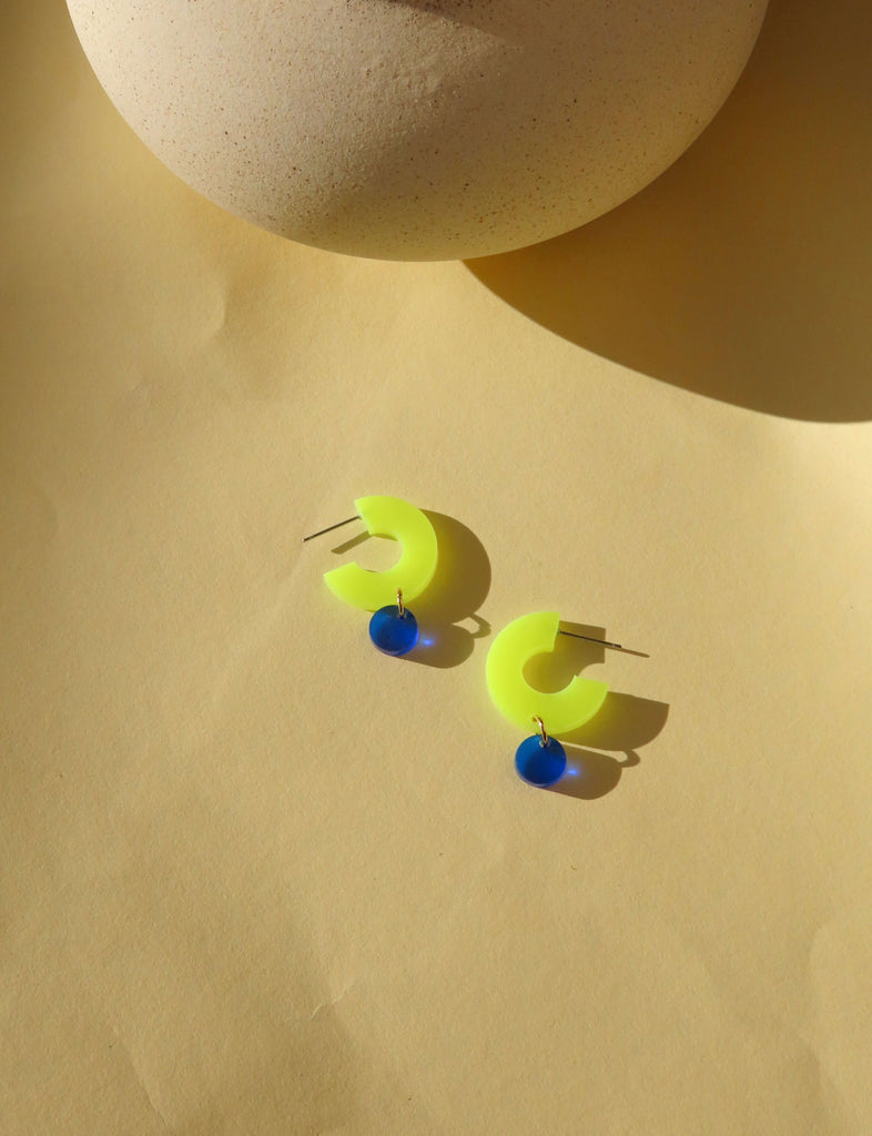 Silva Creolen aus Acryl in Neon-Gelb mit rundem Anhänger in Tiefblau und Edelstahlstecker