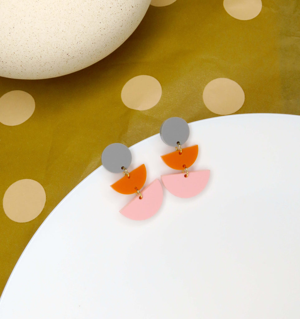 Geometrische Statement Ohrringe aus Acryl mit grauem Kreis, orangefarbenem Halbkreis und rosa Halbkreis