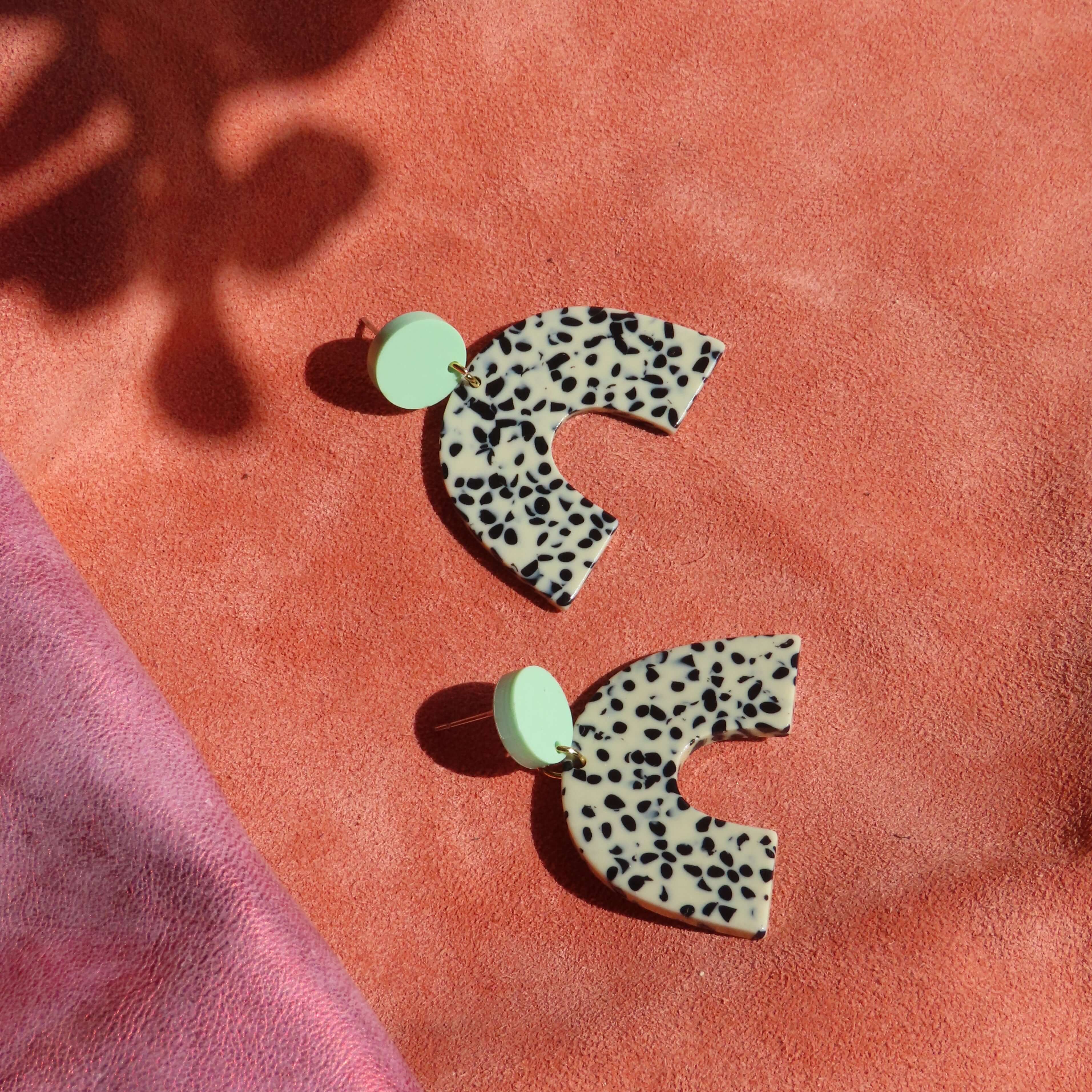 Bogenförmige Acryl-Ohrringe in Greige mit schwarzem Animalprint und rundem mintfarbenem Steckelement