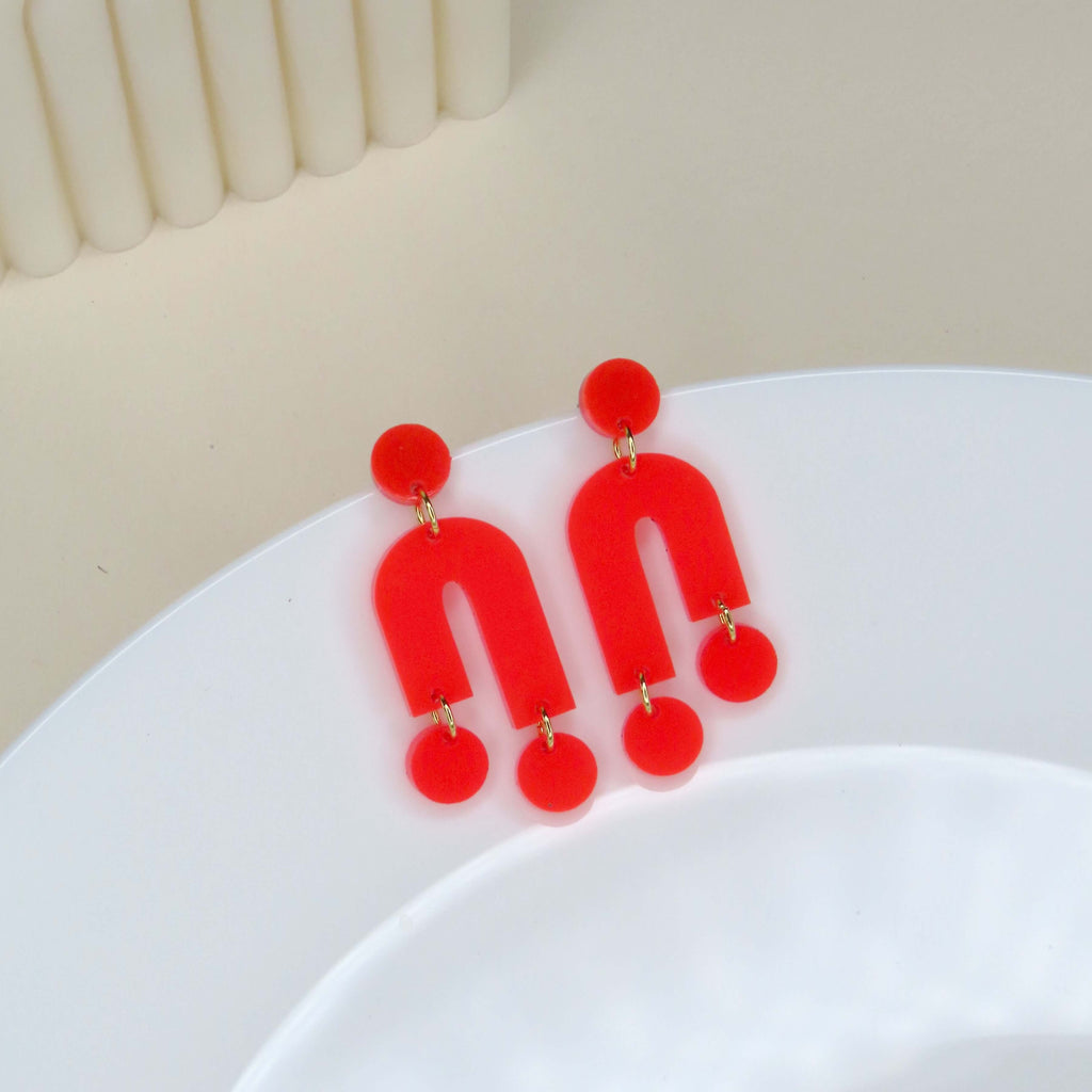 Asymmetrische Ohrringe aus knallrotem Acryl mit Edelstahlsteckern in offen-geschlossener U-Form