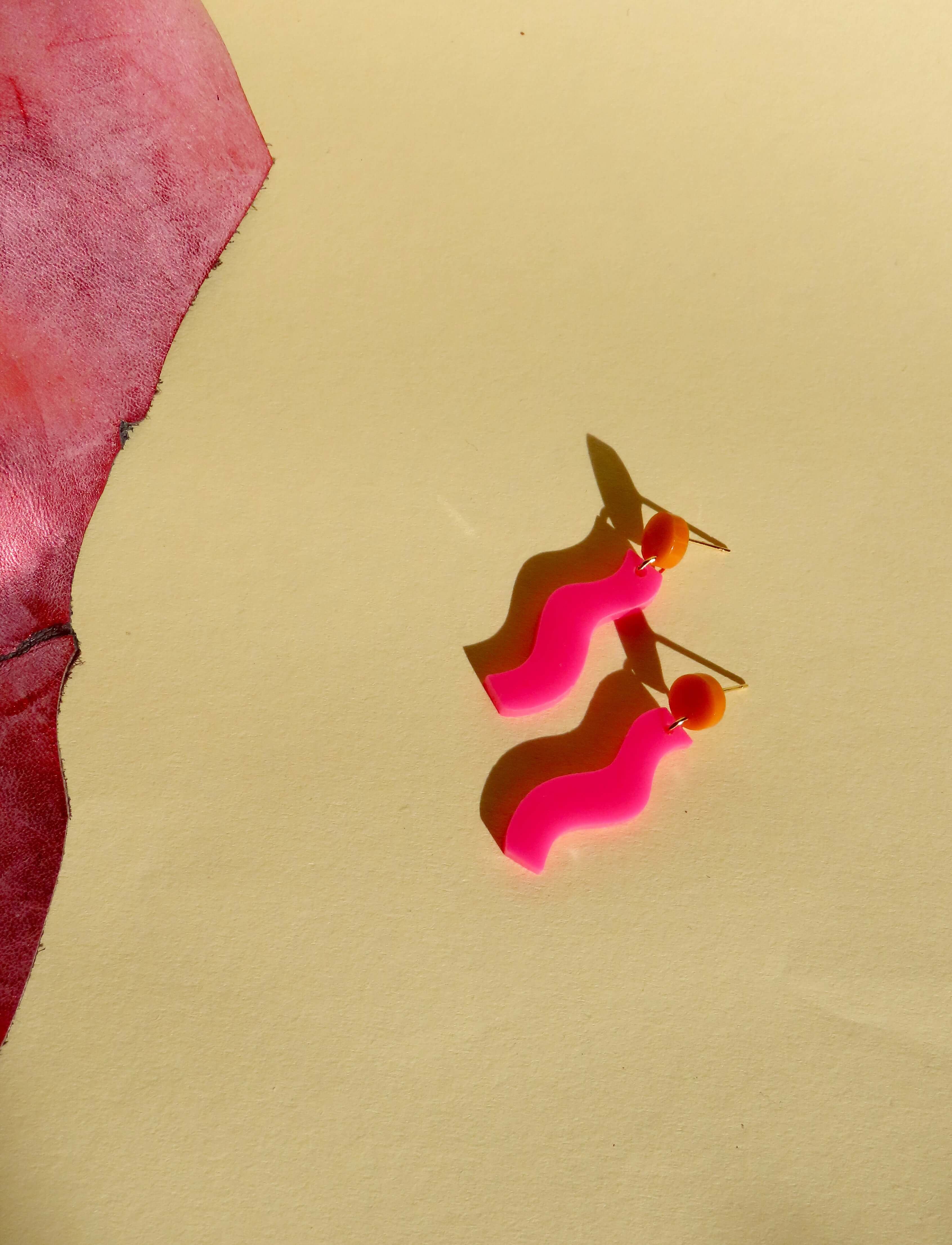 verspielter pinker acryl-ohrring in wellenform mit leuchtend orangefarbenem edelstahl-stecker