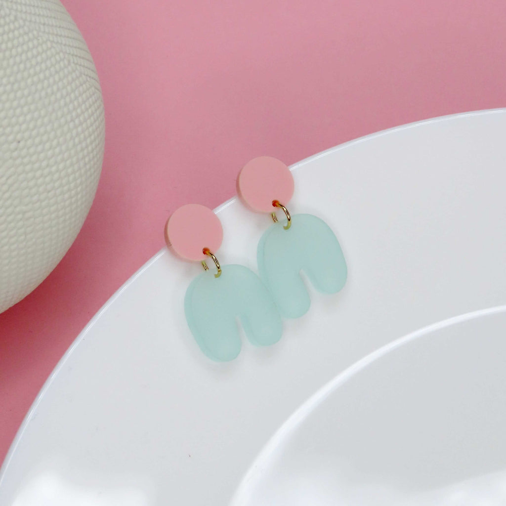 rosa acryl‑ohrring mit mintgrün‑bogen in spielerischer asymmetrischer form