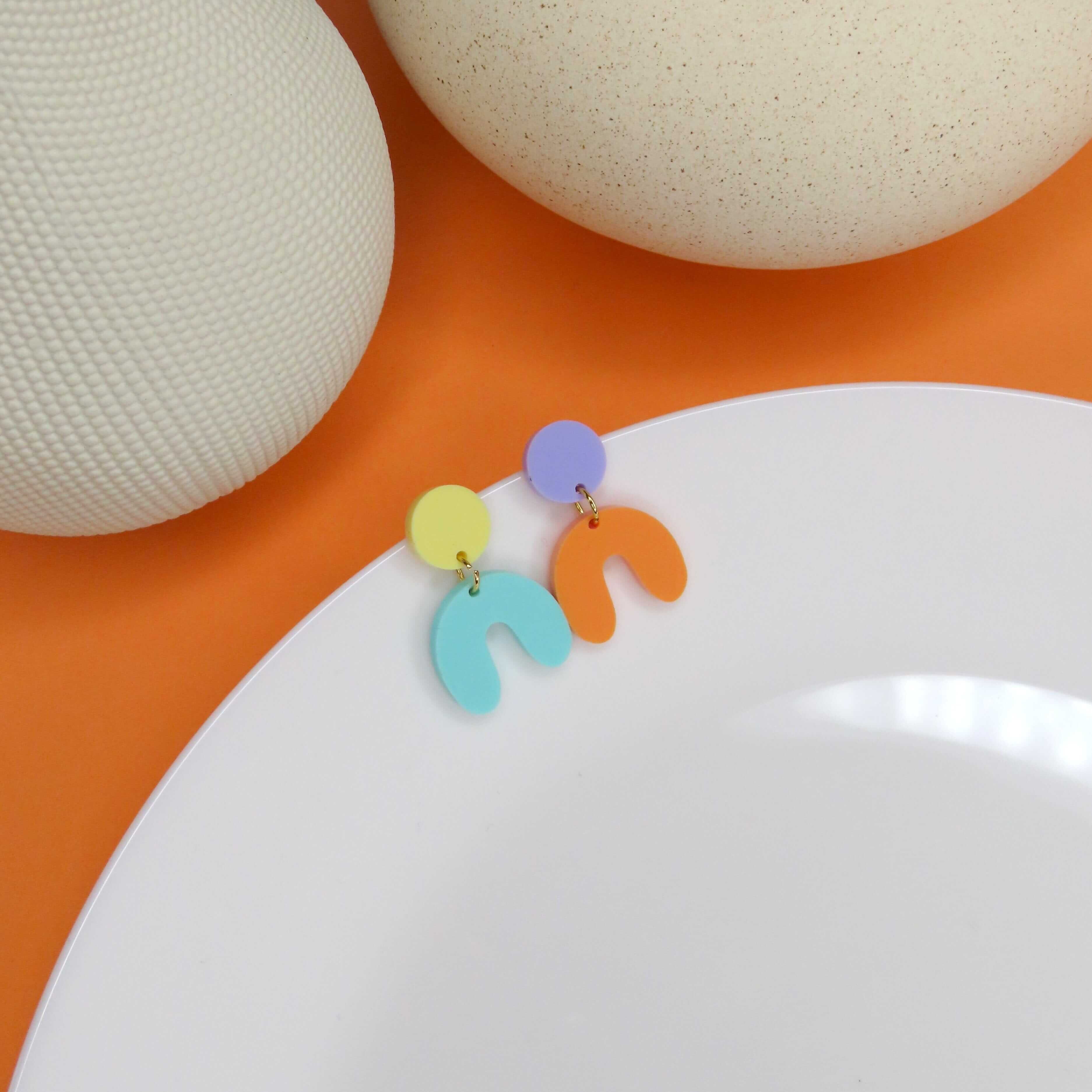 Bunte Acryl-Ohrringe mit gelbem und fliederfarbenem Kreis sowie türkis- und orangefarbenem Hufeisen-Anhänger