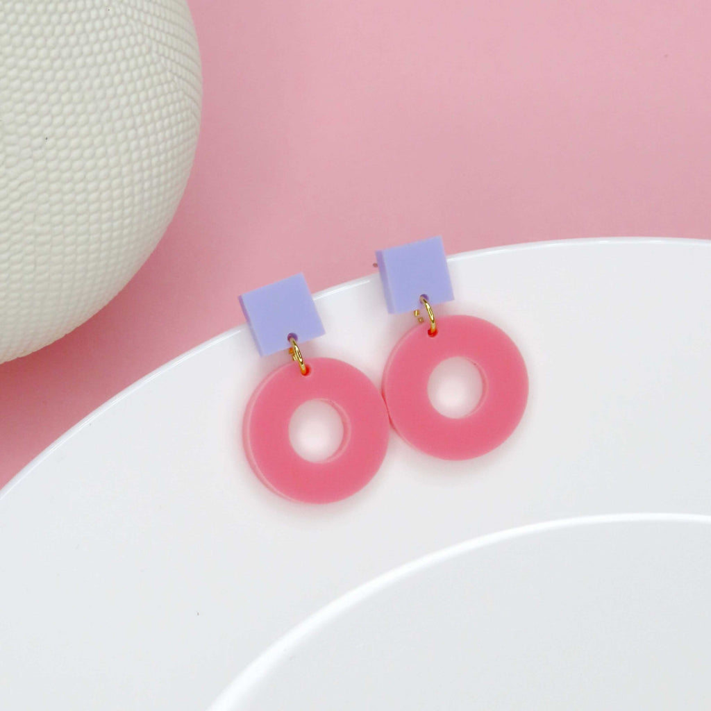 Geometrische Ohrringe aus glänzendem Acryl in Flieder und Rosa mit Donut-Form