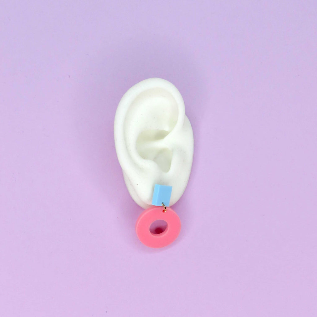 Geometrische Ohrstecker aus Acryl mit hellblauem Quadrat und rosa Kreisring
