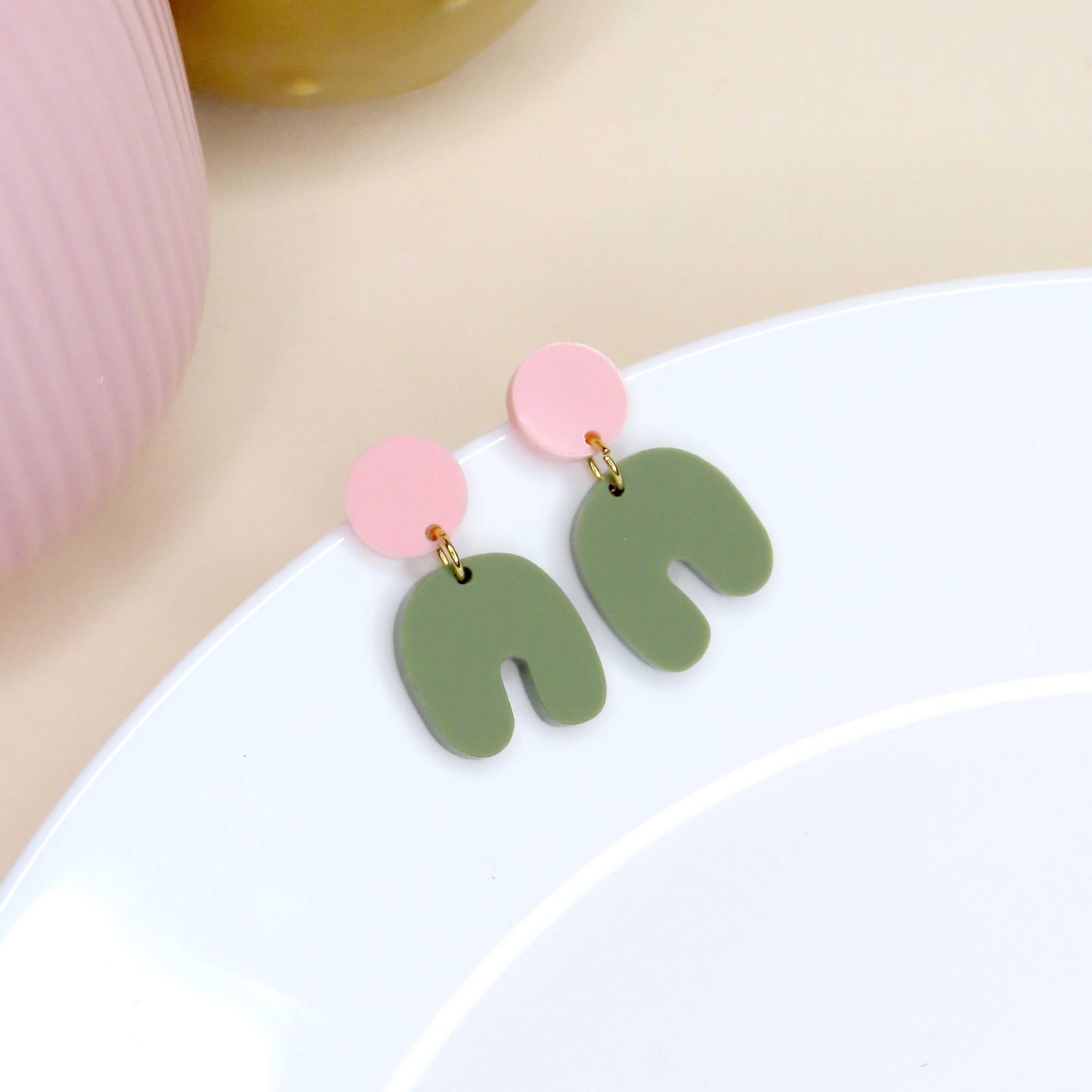 Acryl Ohrringe mit rundem Stecker in Pastellrosa und geschwungenem Bogen in Olivgrün, 3x2 cm, Edelstahlstecker